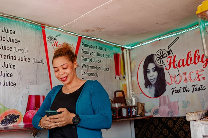 Small business owner checking her phone at her juice stand